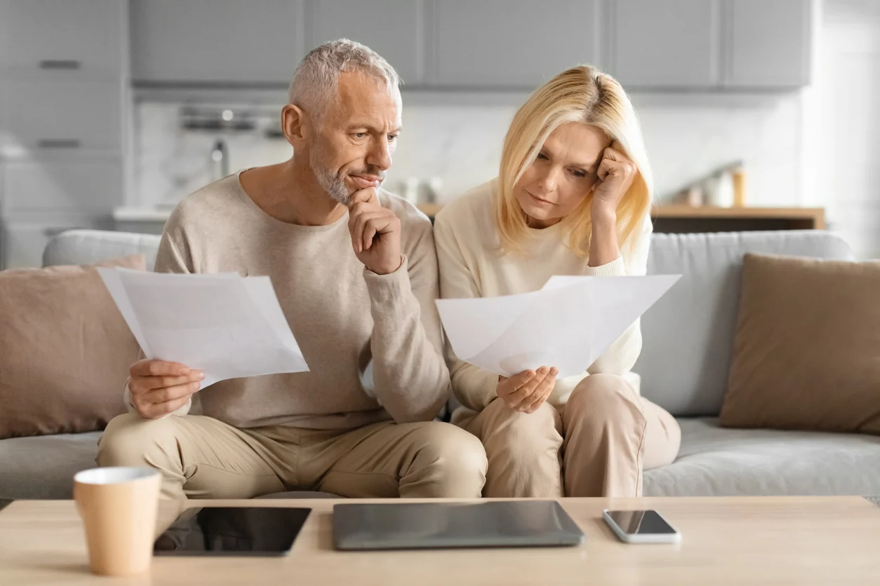 Homeowner reviewing a solar installation contract, proposal, and manufacturer information before verifying the installed solar panels.